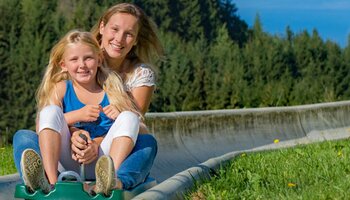 2 Mädchen bei der Sommerrodelbahn Biberg | Saalfelden | © Sommerrodelbahn Biberg