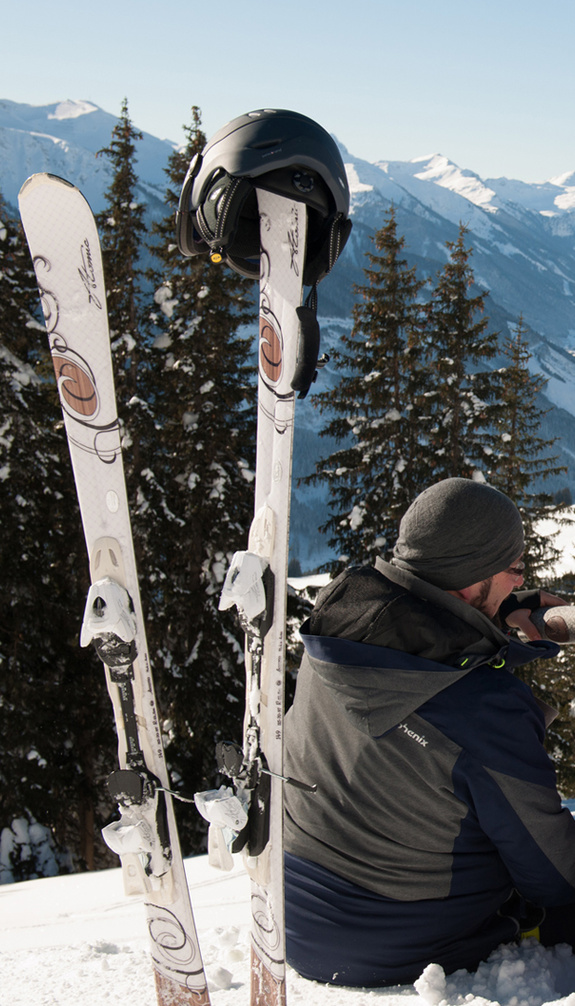 Paar sitz im Schnee am Berg mit Ski im Vordergrund | © viehhofen.at